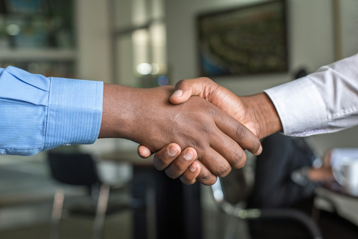 Landlord and tenant shaking hands over a signed lease
